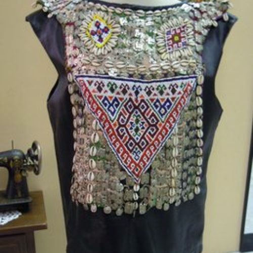 Casaca de cuero adornada con abalorios, conchas y piezas metálicas (delantero)