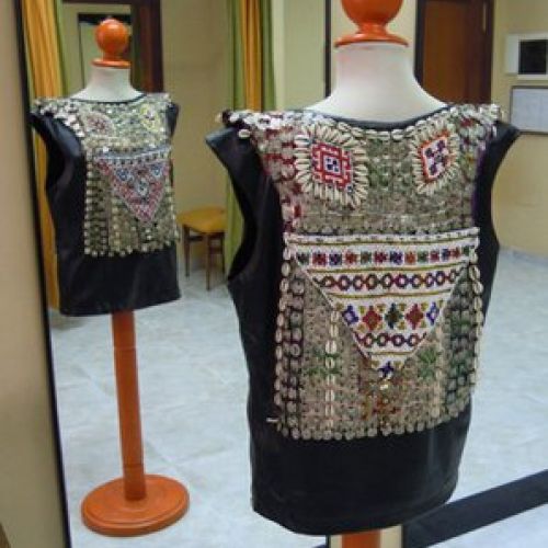 Casaca de cuero adornada con abalorios, conchas y piezas metálicas (trasero)